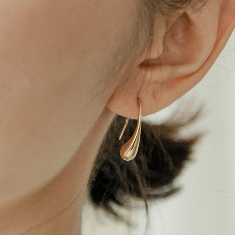 Woman wearing 18K gold plated Waterdrop Earrings from NAZ Parure